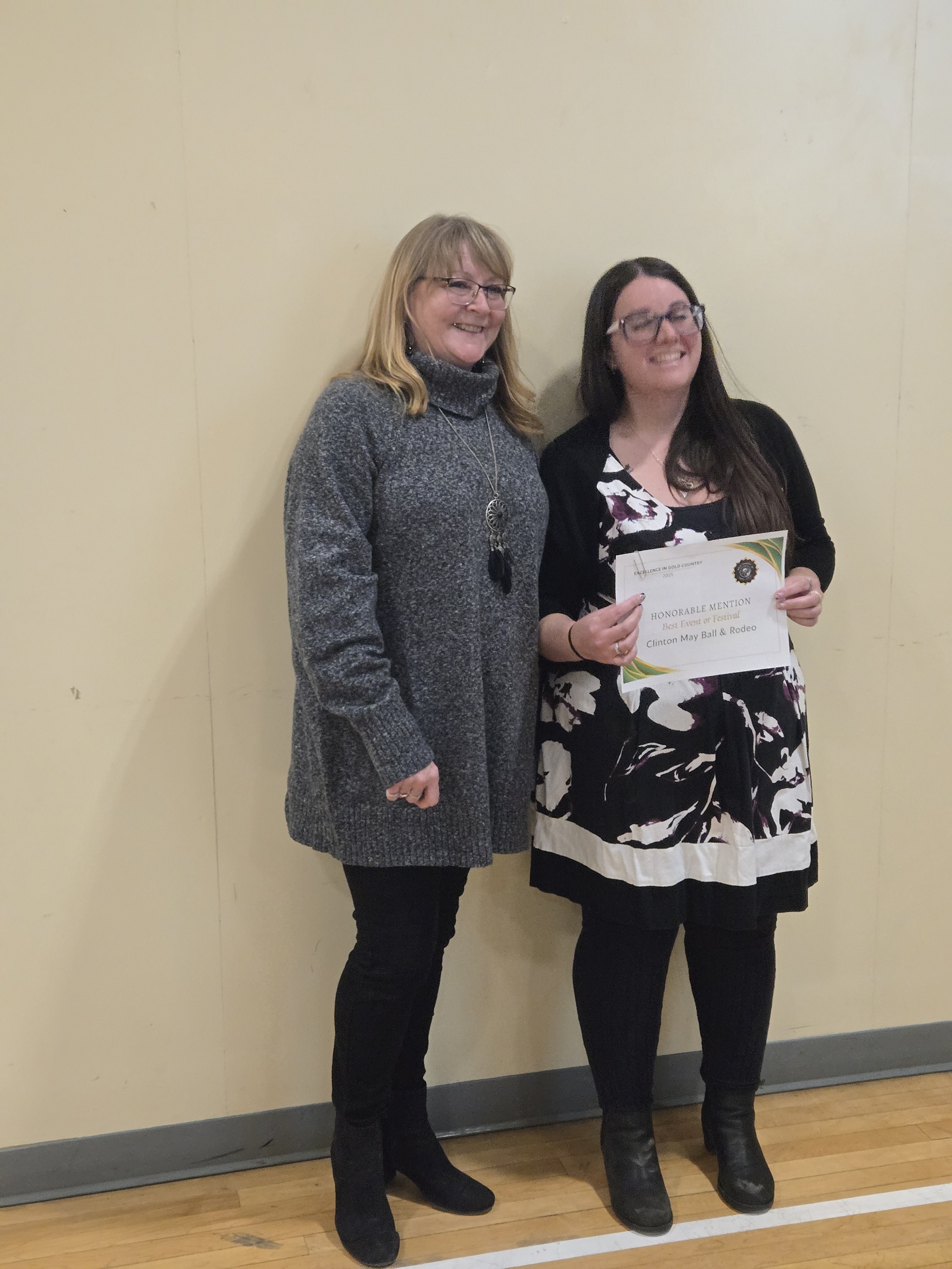 Smiling presenters holding the Clinton May Ball and Rodeo Honourable Mention certificate for Best Event or Festival at the Excellence in Gold Country Awards.